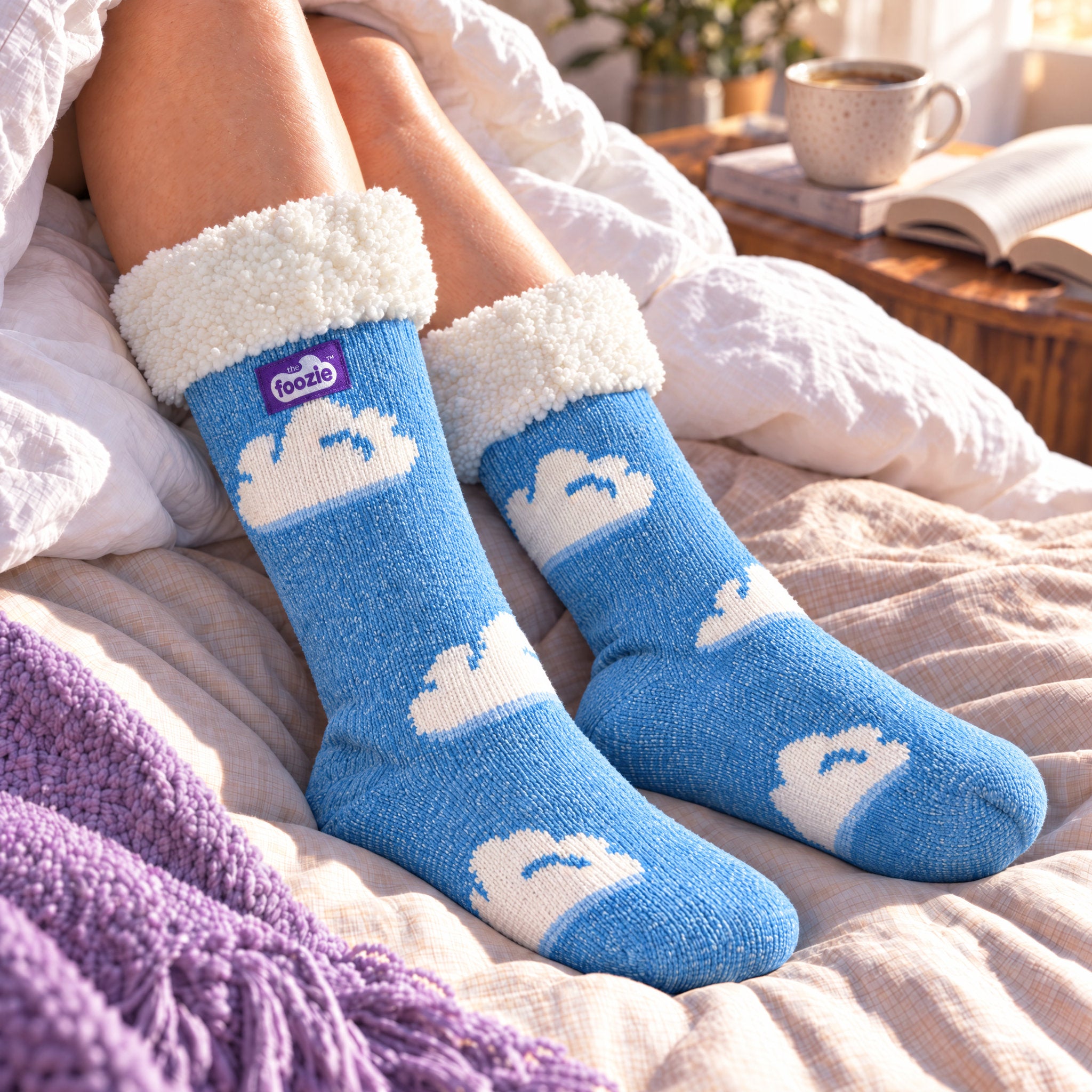 The Foozie™ Cloud slipper socks, on a cosy duvet